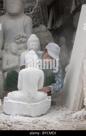 Myanmar (aka Birmania), Mandalay. Intagliatori di pietra di quartiere, l'uomo la levigatura statua del Buddha con power Sander. Foto Stock