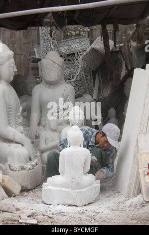 Myanmar (aka Birmania), Mandalay. Intagliatori di pietra di quartiere, l'uomo la levigatura statua del Buddha con power Sander. Foto Stock