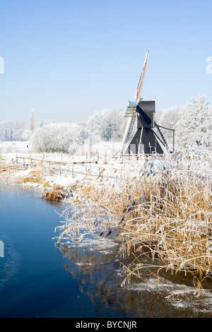 Piccolo Mulino a vento accanto a un fiume in una fredda giornata invernale Foto Stock