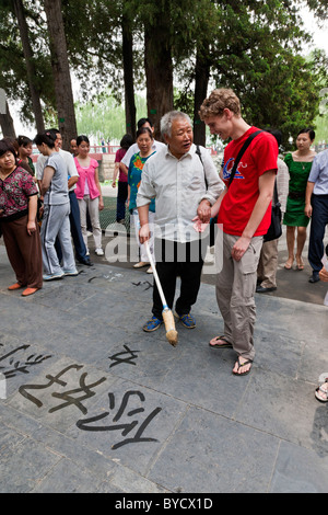 Giovane uomo inglese tourist riceve istruzioni su strada in calligrafia I motivi del nuovo Palazzo Estivo, Pechino. JMH4801 Foto Stock