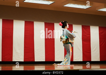 Un grazioso donna giapponese che indossa un kimono tradizionali esegue una danza al Oshogatsu Nuovo Anno di celebrazione in Olympia. Foto Stock