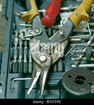 Una coppia di snips sulla parte superiore di un tool kit contenente chiavi a brugola, staccabile screwdrver teste e punte da trapano. Foto Stock