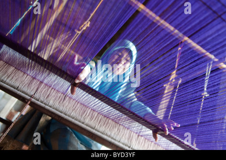 Weaver donna lavora con sorriso sul suo viso Foto Stock