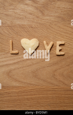 Amore e Parola scritta con biscotti, con una a forma di cuore o Foto Stock