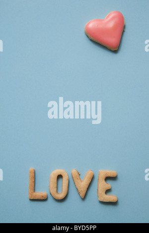 Amore e Parola scritta con biscotti, con un cuore di biscotto a forma di Foto Stock