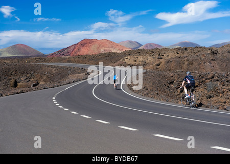 I ciclisti su strada, paesaggio vulcanico a Los Hervideros, Parco Nazionale di Timanfaya, Lanzarote, Isole Canarie, Spagna, Europa Foto Stock