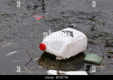 L'acqua sporca, old canister con sostanze corrosive galleggiante sulla pellicola di sporco Foto Stock