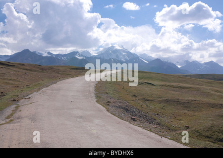 Autostrada che conduce verso le montagne vicino a Sary Tash, Kirghizistan, Asia centrale Foto Stock