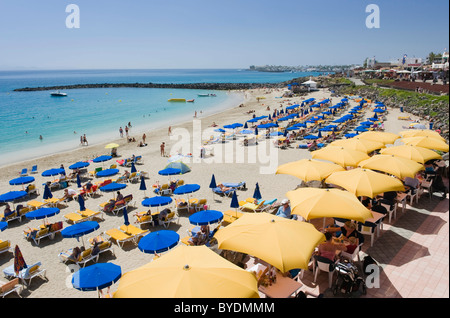 Il giallo sole ombrelloni su di una spiaggia di sabbia, Playa Dorada, Playa Blanca, Lanzarote, Isole Canarie, Spagna, Europa Foto Stock