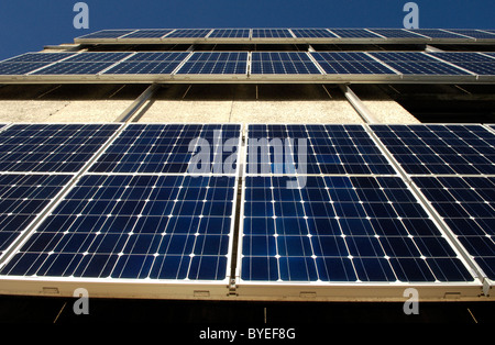 Righe di pannelli solari fotovoltaici sul lato di un edificio del Consiglio in North Devon Foto Stock