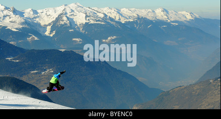 Uno snowboarder esegue un trucco su una cresta nella località sciistica di Courchevel in Francia. Foto Stock