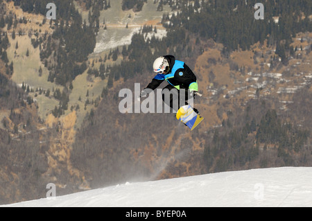 Uno snowboarder esegue un trucco su una cresta nella località sciistica di Courchevel in Francia. Foto Stock