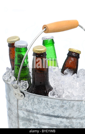 Primo piano di una benna riempita con cubetti di ghiaccio e un assortimento di bottiglie di birra su uno sfondo bianco. Foto Stock