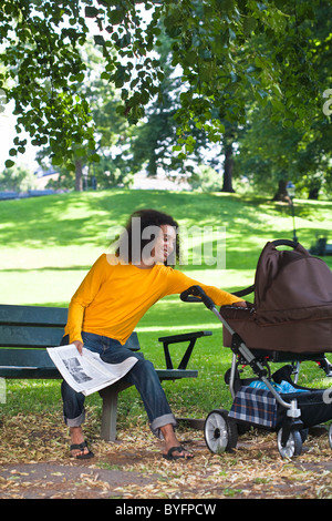 Giovane con bambino trasporto seduta sul banco di lavoro Foto Stock