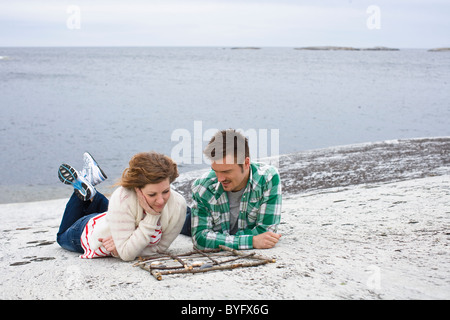 Metà adulto giovane gioca tic-tac-punta sulla spiaggia Foto Stock