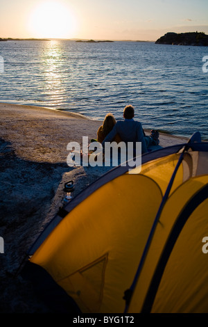 Giovane dal camping mare al tramonto Foto Stock