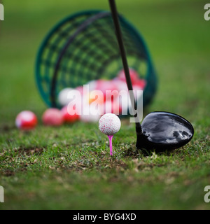 Palla da golf sul raccordo a T accanto al golf club Foto Stock