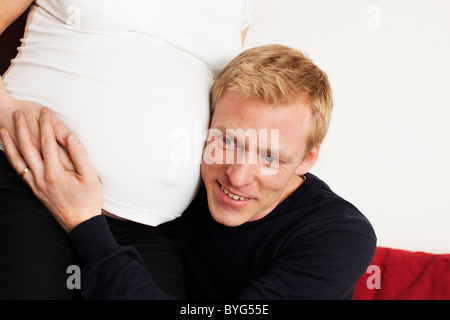 Uomo che ascolta a donne in stato di gravidanza womans stomaco Foto Stock