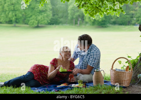 Coppia giovane avente picnic nel parco Foto Stock