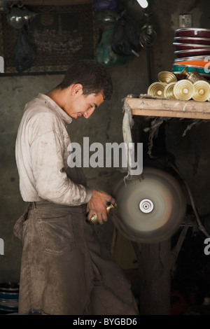 Un lavoratore metalmeccanico lavorando nella sua officina nel souk, medina di Marrakech, Marocco, Africa del nord Foto Stock