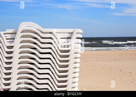 Impilati sedie a sdraio - fine dell'estate sulla spiaggia di sabbia di Sopot. La Polonia. Foto Stock