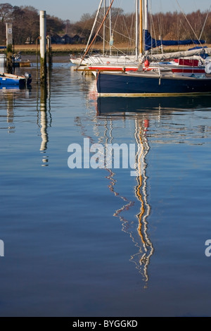 Yacht ormeggiato sul fiume Hamble con riflessioni di piloni in acqua Foto Stock