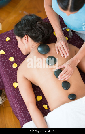 Donna con terapia lastone a health spa Foto Stock