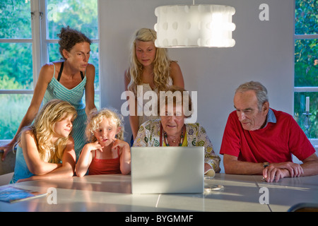 Tre generazioni la famiglia tramite computer portatile Foto Stock