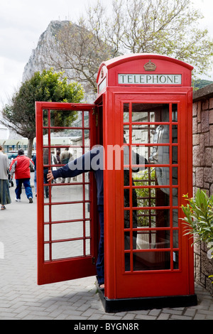Persona / turistico con porta aperta: rosso originale K6 telefono / telefono casella chiamata su Gibilterra, vicino al confine con la Spagna. Rocca di Gibilterra Foto Stock