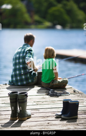 Padre con figlio pesca, stivali di gomma in primo piano Foto Stock