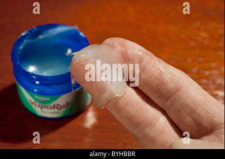 Un dab di Vicks Vaporub rimedio a freddo su un uomo le dita Foto Stock