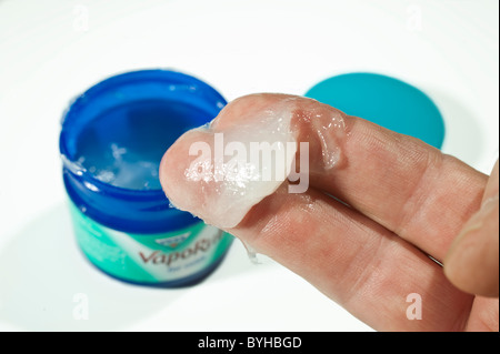 Un dab di Vicks Vaporub rimedio a freddo su un uomo le dita Foto Stock