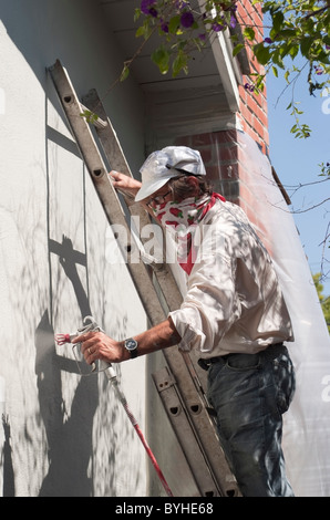 Proprietario della pittura la parte esterna di un unica famiglia, ranch stile home in San Jose, CA prima di mettere la casa in vendita. Foto Stock