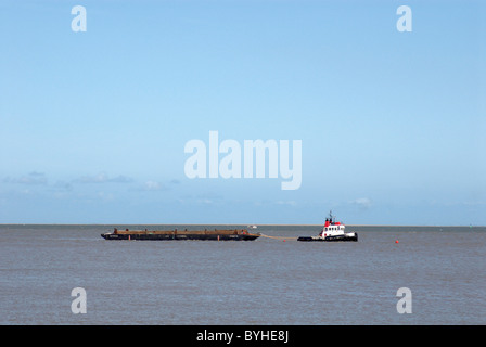 Rimorchiatore tirando una chiatta di materiale di servizio pesante Great Yarmouth Regno Unito Foto Stock