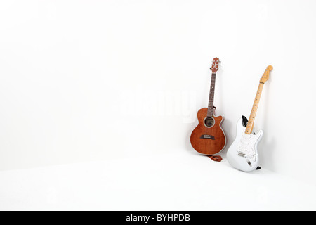 Due chitarre in un angolo di una stanza bianca Foto Stock