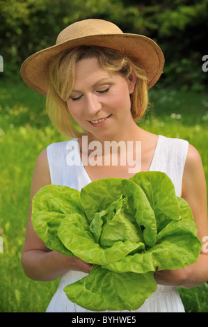 Giovane donna azienda lattuga fresca Foto Stock