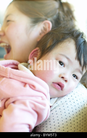 Baby appoggiato la testa sulla Madre di spallamento Foto Stock