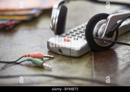 Telecomando, Cuffie e riviste sul piano del tavolo Foto Stock