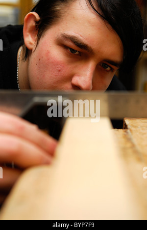 Giovane uomo guadagnando abilità di falegnameria come parte di un'iniziativa per ottenere i giovani nel lavoro, Bristol, Regno Unito. Foto Stock