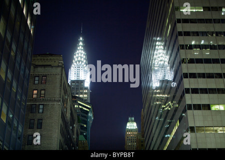 Stati Uniti d'America, New York New York City, il Chrysler Building è riflessa nel vetro esterno del vicino edificio per uffici di notte Foto Stock