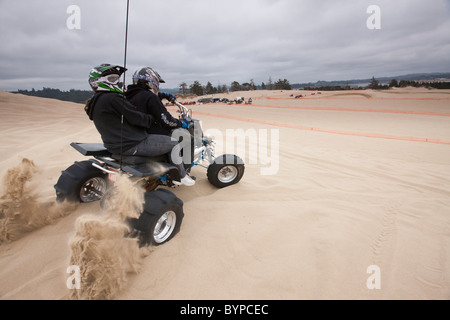 Stati Uniti d'America, Oregon, North Bend, giovane corse su ATV da alta cresta di sabbia a Oregon Dunes National Recreation Area Foto Stock