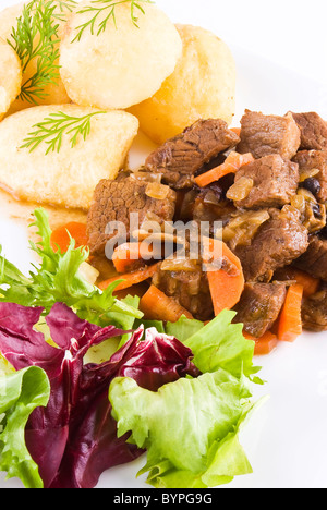 Pasto di stufati di carne di manzo con patate arrosto e insalata fresca Foto Stock