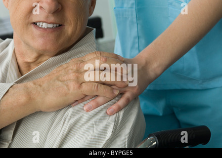 Paziente infermiera tenendo la mano, ritagliato Foto Stock