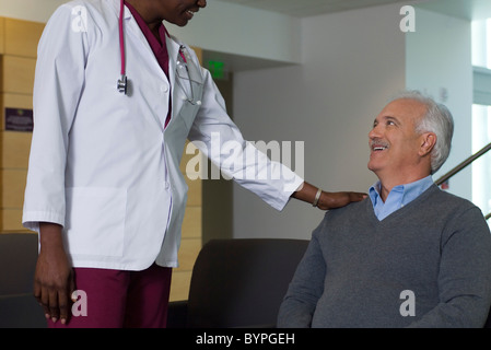 Medico paziente rassicurante in sala d'attesa Foto Stock