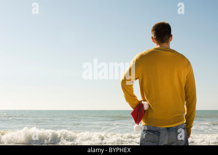 Giovane uomo a beach cercando di visualizzare Foto Stock