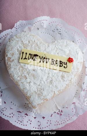 A forma di cuore con pasticceria scritte sui decorativi di cioccolato bianco lettura, "ti amo baby' Foto Stock