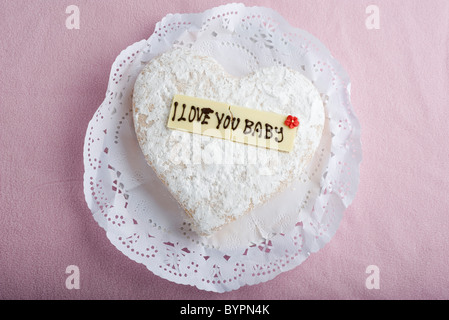 A forma di cuore con pasticceria scritte sui decorativi di cioccolato bianco lettura, "ti amo baby' Foto Stock