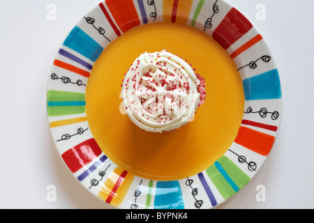 Guardando verso il basso sulla Red Velvet cupcake sulla colorata gialla - piastra da sopra Foto Stock