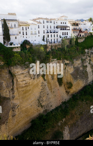 Spagnolo tradizionale edificio bianco di sviluppo / edifici che si affacciano su una profonda El Tajo gorge & fiume Guadalevin, Ronda, Spagna. Foto Stock