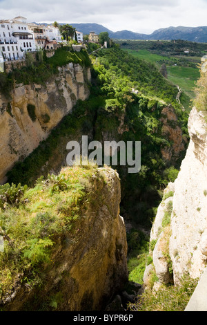 Spagnolo tradizionale edificio bianco di sviluppo / edifici che si affacciano su una profonda El Tajo gorge & fiume Guadalevin, Ronda, Spagna. Foto Stock